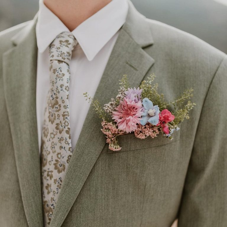 Boutonnière colorée avec fleurs délicates sur un costume vert.
