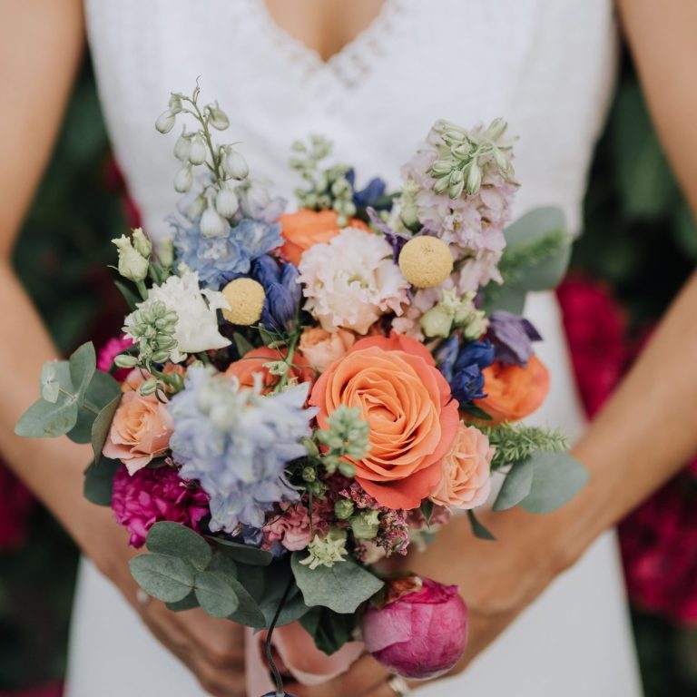 Bouquet de fleurs colorées, incluant des roses, des pivoines et des feuillages.